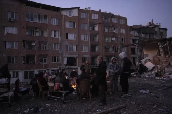 Friends and relatives of the Dagli family family gather around bonfires while rescue teams, search for family members under the rubble of a destroyed building in Antakya, southeastern Turkey, Wednesday, Feb. 15, 2023. |AP/PHOTO.