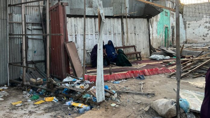 Hopeless: Women sit among the rubble of demolished houses in Ex-Carwada Taleex, Mogadishu's Hodan district, where a public auction has taken place, benefiting greedy businessmen and corrupt government officials.