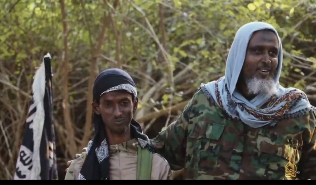 Al-Shabaab spokesperson Ali Mahmoud Rage (Ali Dheere) appears in the video alongside his 20-year-old son, Abdifatah, as they speak about the suicide unit being prepared for the attack. The group claims that Ali Dheere’s son was among those killed in the operation.